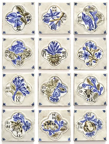 Twelve decorative cream ceramic tiles featuring hand-drawn blue botanical illustrations, birds and lettering