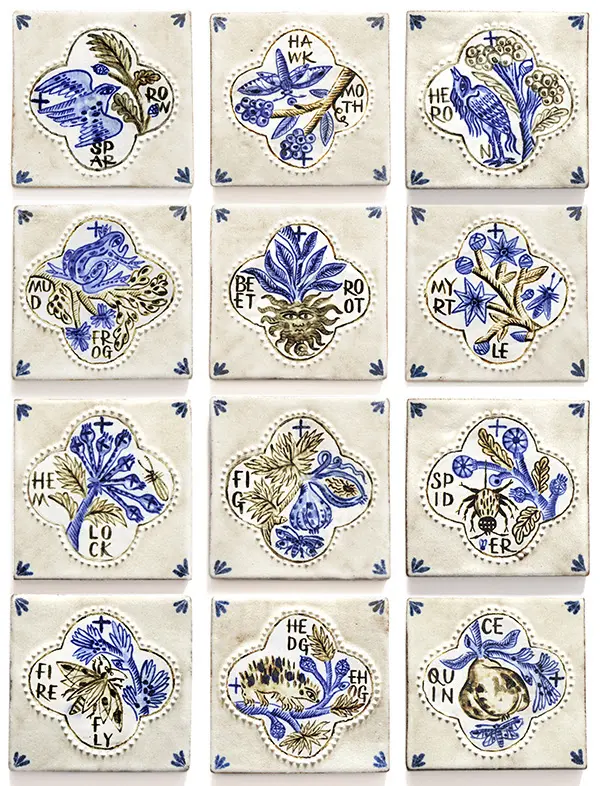 Twelve decorative cream ceramic tiles featuring hand-drawn blue botanical illustrations, birds and lettering
