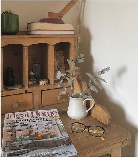 We love interiors magazines! Lifestyle image of a wooden dresser with a collection of items.