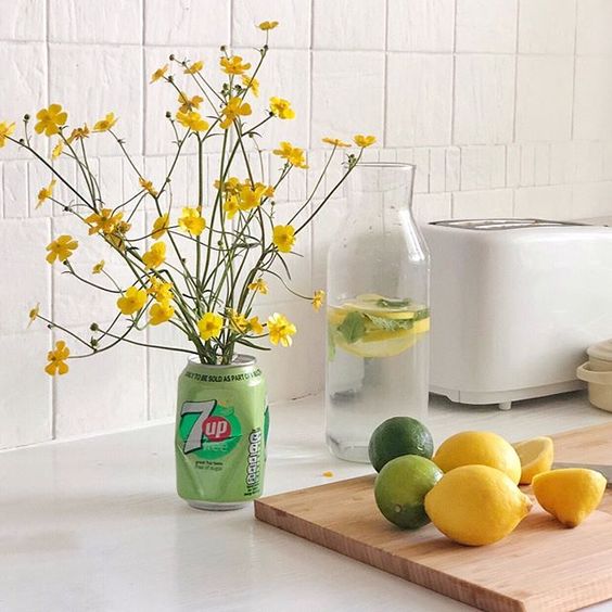 The secret styling tip for adding personality to your home that you need to know! Lifestyle vignette of some flowers styled in a 7Up can with some lemons and limes