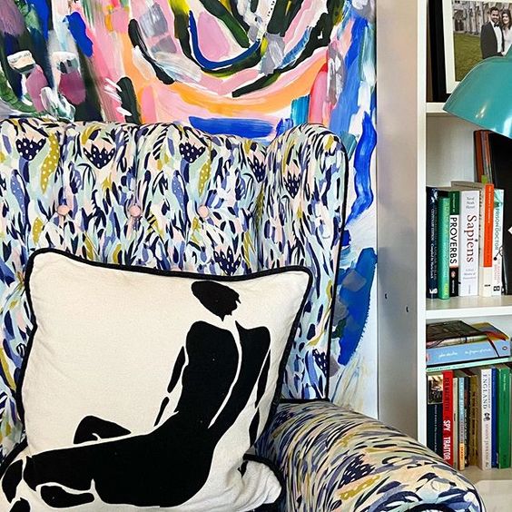 How to use colour in a room. Reading chair with a bold blue pattern and monochrome cushion with a black silhouette