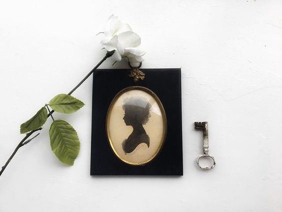 The secret styling tip for adding personality to your home that you need to know! Flat lay of a portrait with a single stem flower and vintage key