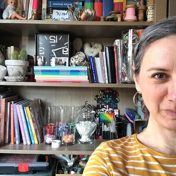 The secret styling tip for adding personality to your home that you need to know! Woman sitting in front of open shelves with a collection of books