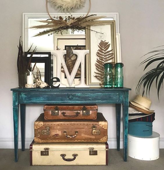 20 of the best vintage interiors in the UK. A collection of vintage suitcases underneath a turquoise vintage table