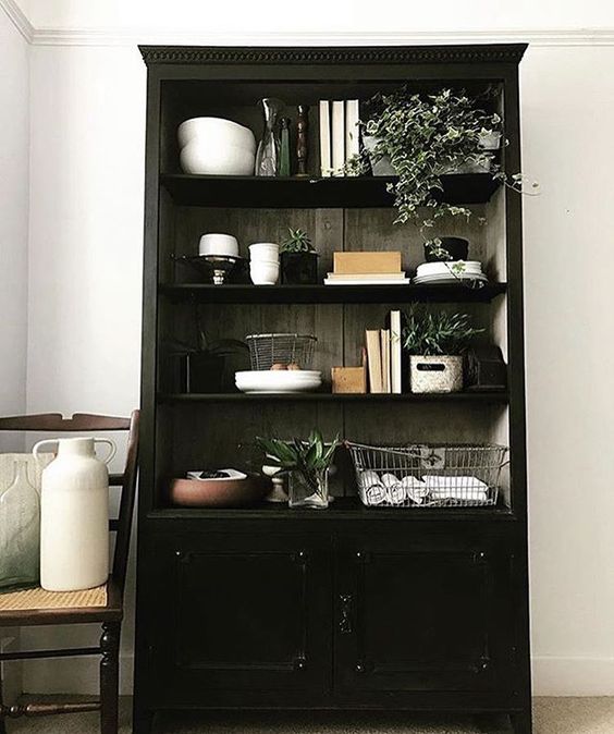 The secret styling tip for adding personality to your home that you need to know! Black dresser with lifestyle items such as books and vases