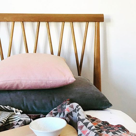 How to use colour in a room. Mid-century modern bed frame with blush pink and dark grey cushions