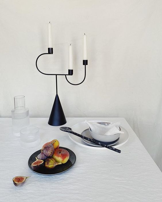 The secret styling tip for adding personality to your home that you need to know! Lifestyle vignette of a black, sculptural candlestick and cut figs