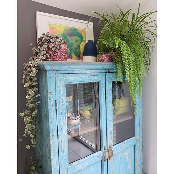 20 of the best vintage interiors in the UK. Vintage blue dresser with vintage crockery and plants