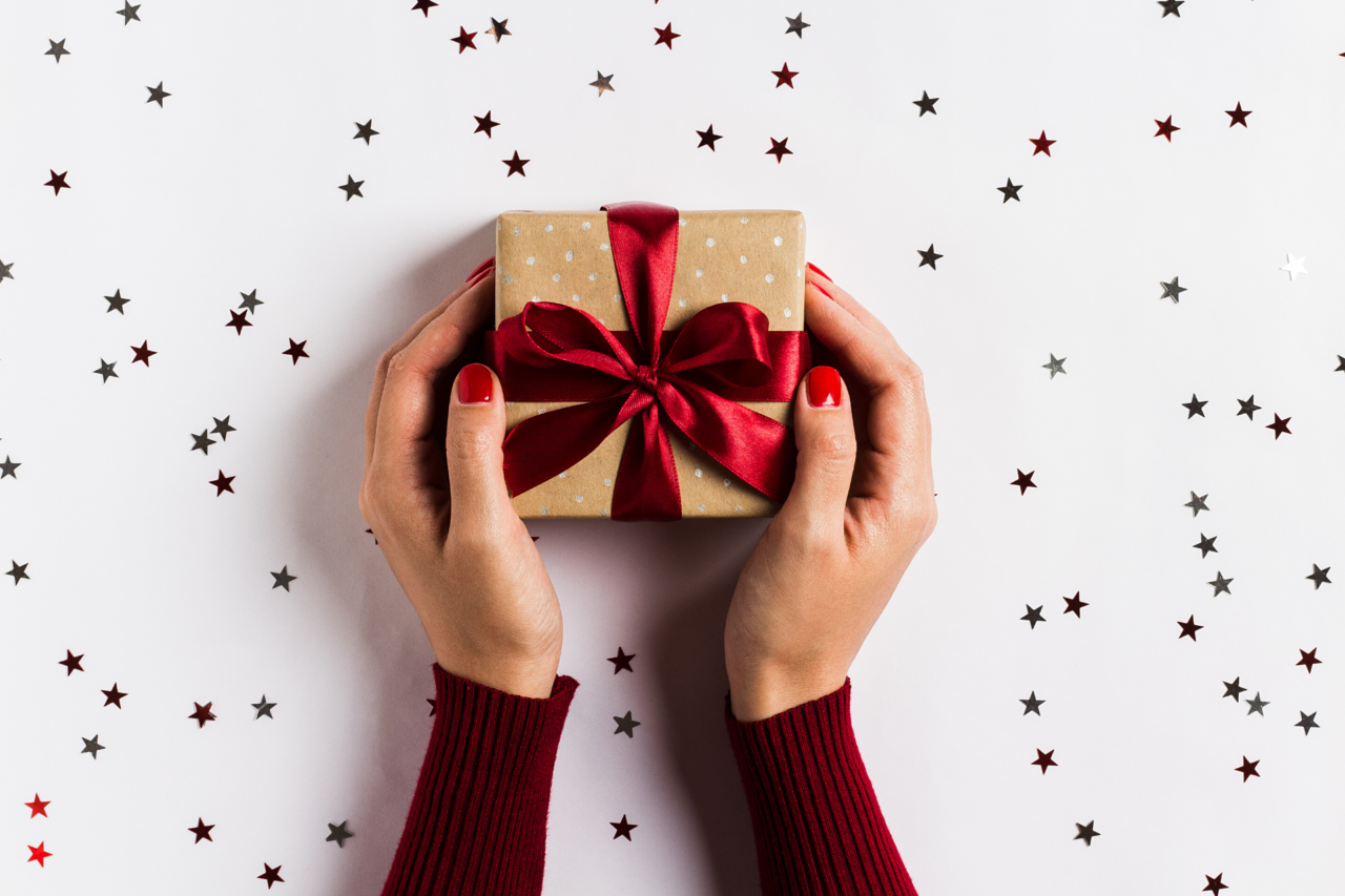 Christmas shooting. Подарок в руках. Розыгрыш подарков. Руки протягивают подарок