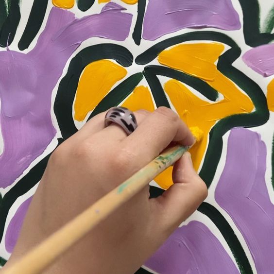 19 creative ways to use paper. Image of a hand painting a yellow flower.