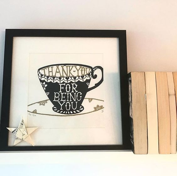 19 creative ways to use paper. Lifestyle shot of a shelf containing books, an art print and a paper star