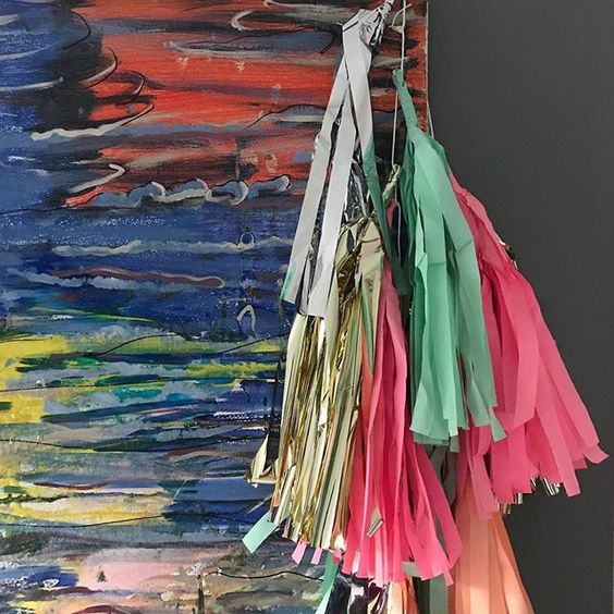 19 creative ways to use paper.Colourful paper decorations hung over a colourful abstract painting.