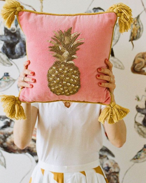 How to stay positive online in 2020. Lady hiding behind a pink cushion with a gold pineapple