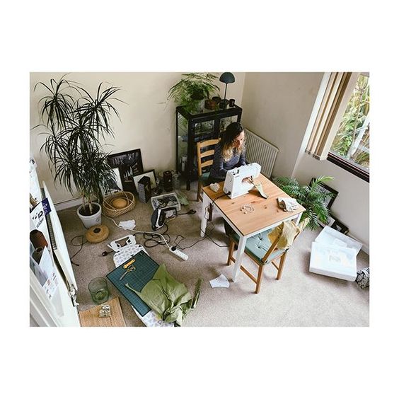 How to stay positive online in 2020. Birdseye shot of a room with a lady sewing at a table and green plants.