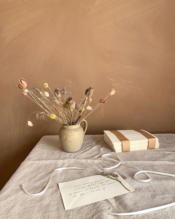 19 creative ways to use paper. Lifestyle still life of paper, a wrapped book and some dried flowers styled on a linen tablecloth