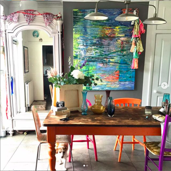 Colourful dining room with brightly painted chairs and artwork