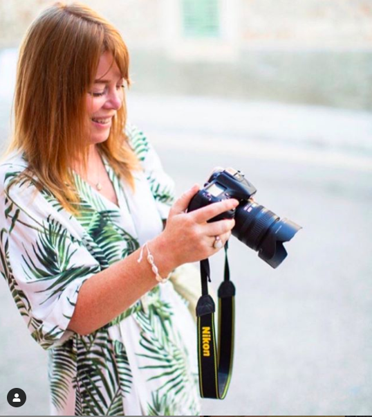 Female photographer looking at her camera viewfinder.