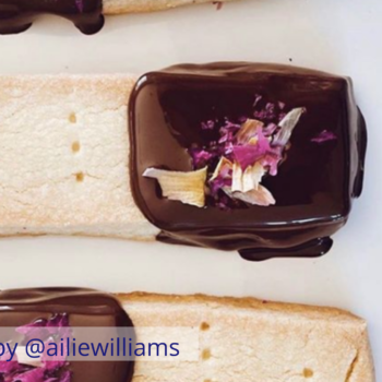 Food styling featuring shortbread biscuits dipped in chocolate with rose petals
