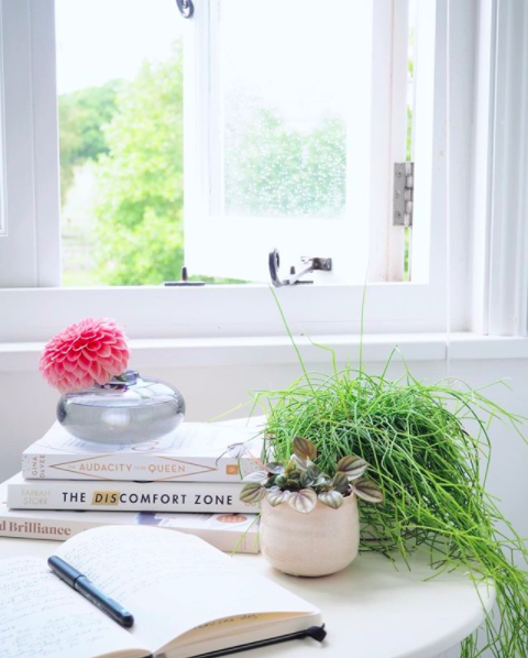 My happy place. A shot of an open window styled with some books and a plant pot in front of it.