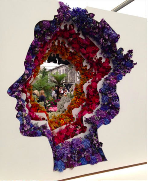 Floral art installation of brightly coloured flowers creating the Queen's head