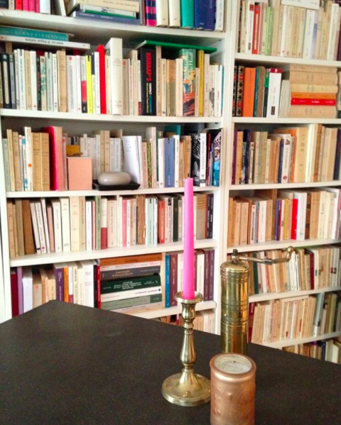 My happy place. An apartment in Paris with a full bookshelf and pink candles.