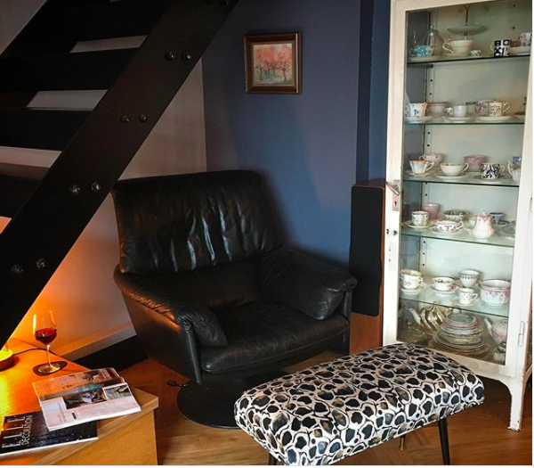 My happy place. Shot of a dark leather chair underneath a set of stairs in a living room.