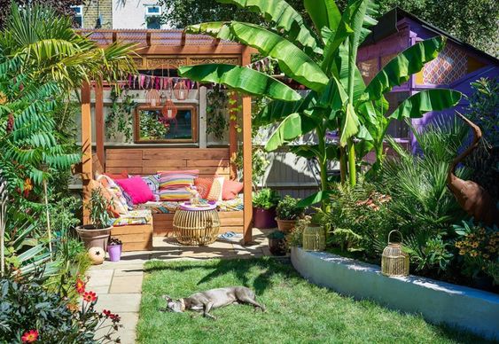 My happy place. Colourful garden with homemade wooden seating and colourful scatter cushions.