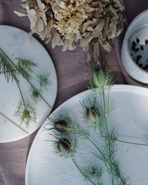 Lifestyle shot of some thistles styled on top of elegant table ware.