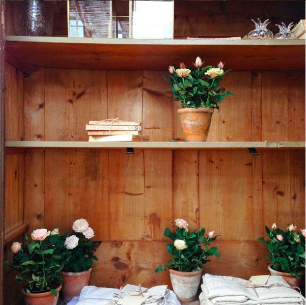 Styling an open wooden dresser with plants and vintage linens