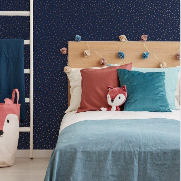 Image of a child's bedroom featuring navy wallpaper with gold polka dots