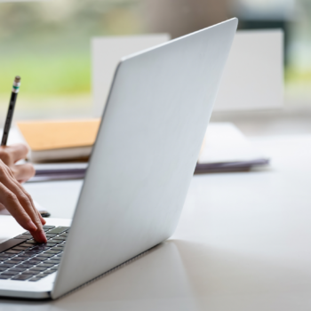 Woman typing on a laptop probably signing up to the Inside Stylists newsletter