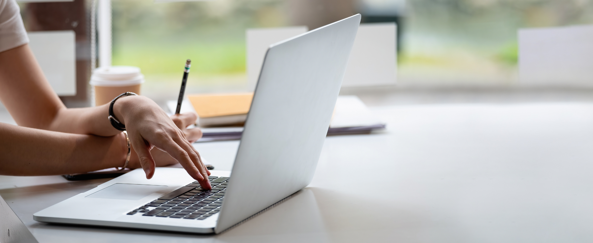 Woman typing on a laptop probably signing up to the Inside Stylists newsletter