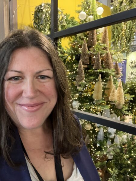 Hannah Bartlett of JollyFestive.com standing by a Christmas window