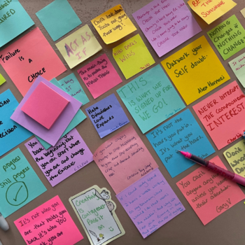 A desk full of post-it notes with quotes on them