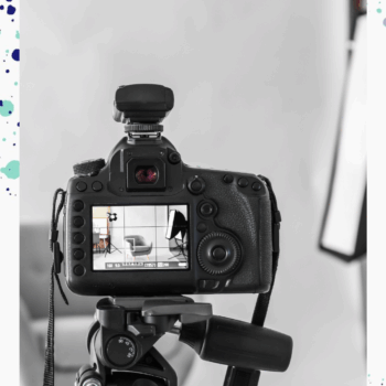 We're looking at the back of a camera screen that is taking a photo of a room set. The camera is black and the room is white and grey